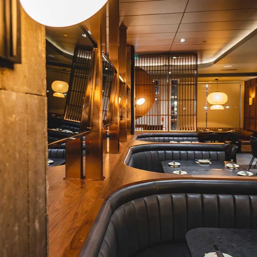 Dark Booth seating with wood and glass fixtures surrounding in Tozen Sushi Bar